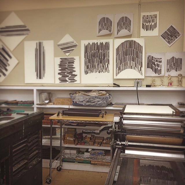 Image prints pinned to a wall in the letterpress studio